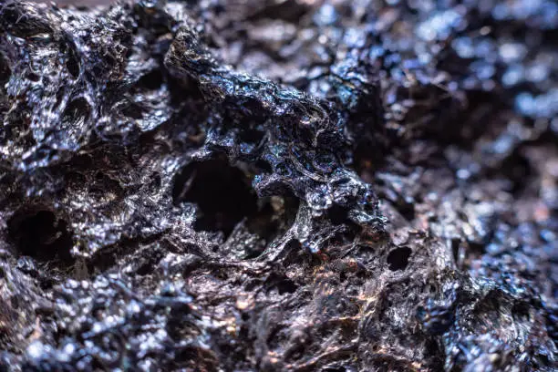 Photo of Macro of slag or volcanic magma stone texture, similar to a landscape of a strange space planet
