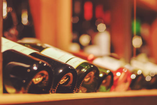 와인 숍이나 바에서 많은 병이있는 와인 스탠드의 소프트 포커스 배경 - liquor store 뉴스 사진 이미지