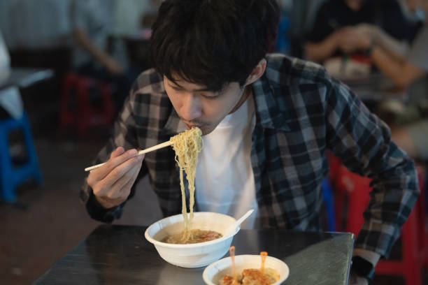 istock Young man eating dinner at street food 1256166468