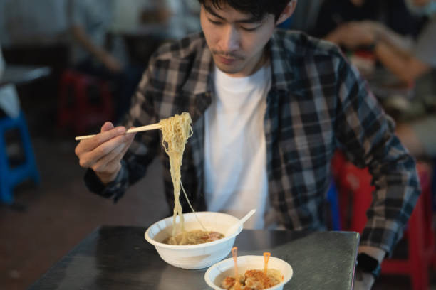 istock Young man eating dinner at street food 1256166556