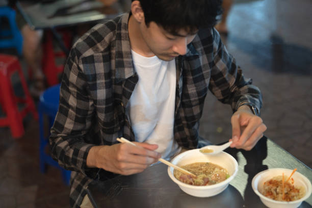 길거리 음식에서 저녁 식사를 먹는 청년 - thai cuisine thailand asian cuisine chinese cuisine 뉴스 사진 이미지