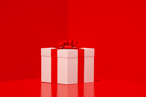 White gift box is sitting inside of another gift box on red background. Vertical composition with copy space, Great use for sale concepts.