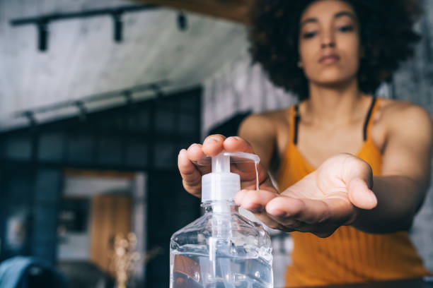 Afro woman applying hand sanitizer,during Covid-19