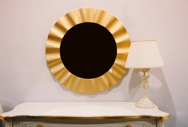 istock Golden round frame mirror on the white wall and white lamp 1256174155
