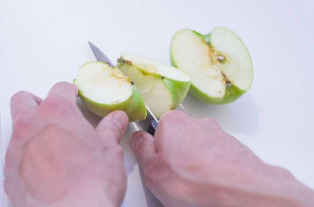 istock Female hands cutting apple with knife. 1256178146