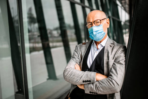 istock Mature businessman with face protective mask 1256184552