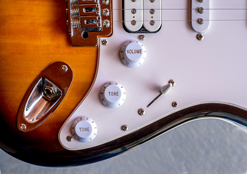 closeup from an electric guitar, volume and tone switch and some strings