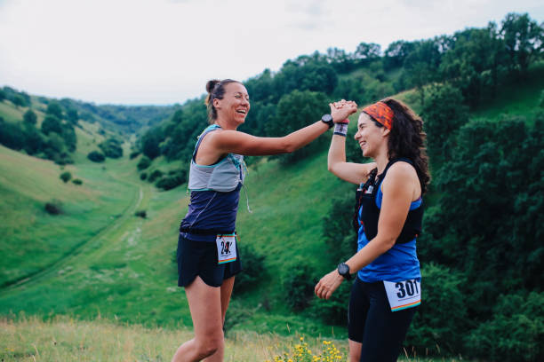 istock Two female runners celebrate in the nature 1256190328