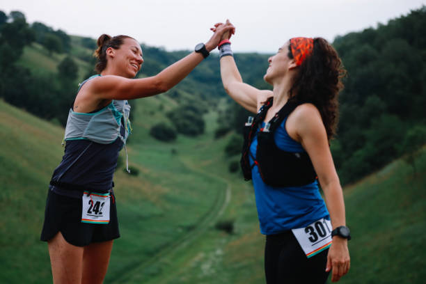 istock Two female runners celebrate in the nature 1256193397