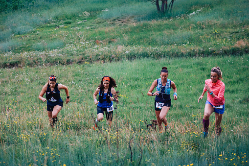 A group of female athletes running a marathon in the nature.