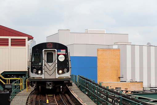 Elevated subway train entering station in Queens,