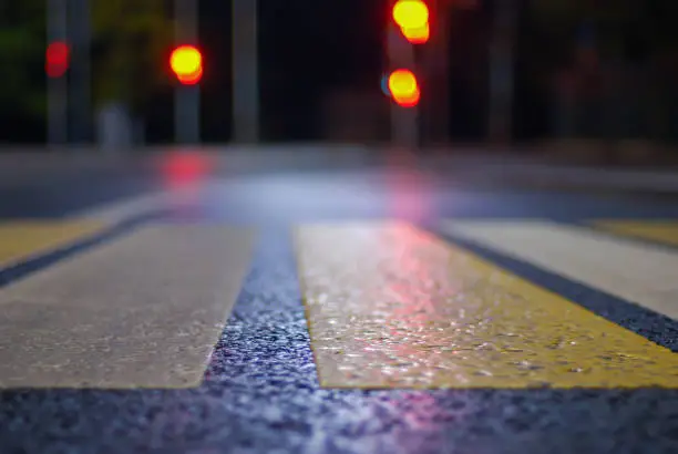 crosswalk at night street, blurred   traffic lights, defocused city background