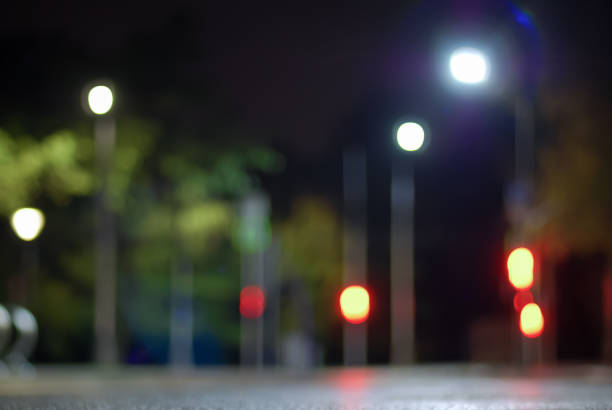 istock Blurry traffic lights background at night, empty city street defocused view 1256195538