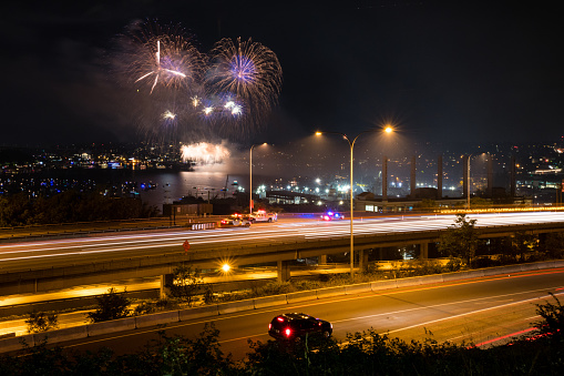 Seattle, USA - July 4th, 2019: Fireworks over lake union as an SUV dangerously stops on northbound Interstate 5 just after 10:20pm as the fireworks start.