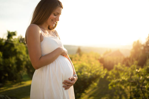 young woman expecting a baby. - dress human pregnancy young women women imagens e fotografias de stock