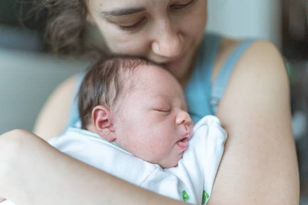 istock New mom snuggles her newborn daughter 1256201836