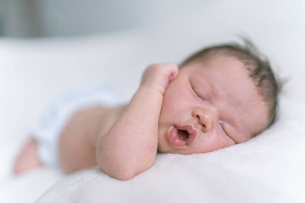 istock Newborn mixed race girl sleeps soundly on a bed 1256201848