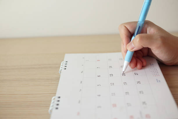 istock Hand with pen writing on calendar date 1256201987