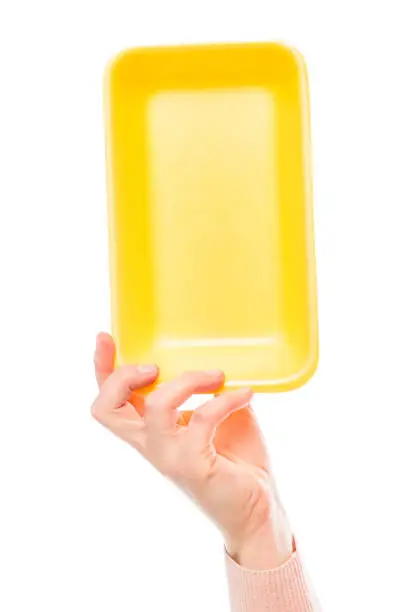 Yellow foam polystyrene packaging in female hand on a white background