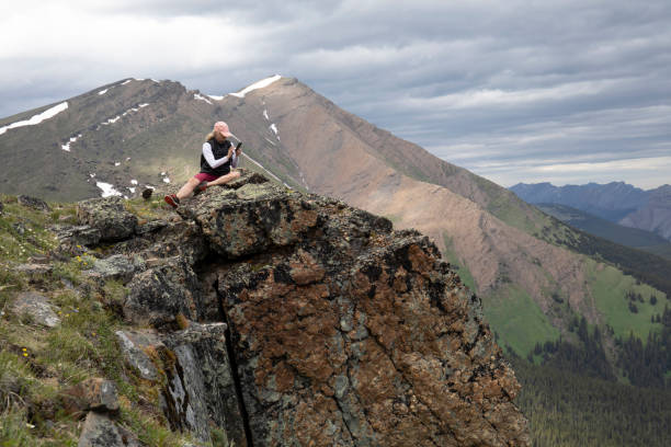 istock Female hiker relaxes on mountain ridge in the spring 1256210046