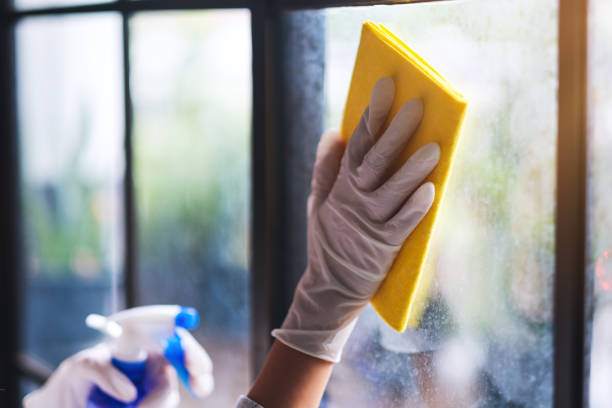istock A housekepper wearing protective glove cleaning the window 1256213220