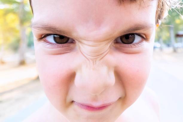 Headshot of a pouting little girl with a bad attitude isolated on a black background.