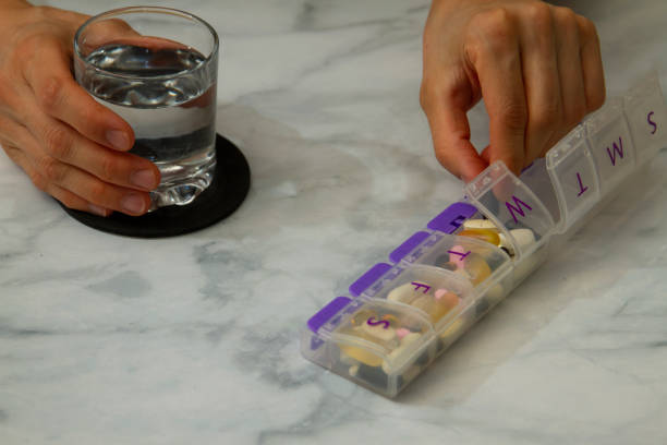 istock a women is taking a tablet out of a pill box 1256218732
