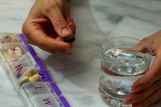 istock a women is taking a tablet out of a pill box 1256218747