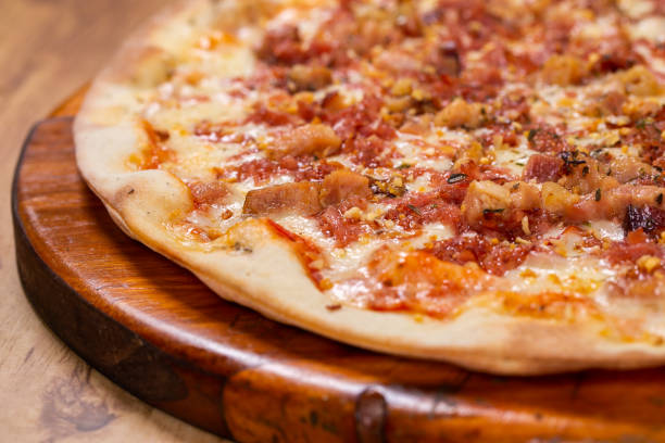istock pizza with bacon and fried garlic on wooden background. top view 1256219547