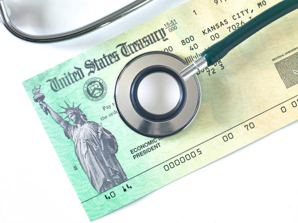 goverment check and stethoscope - currency stethoscope medicare usa imagens e fotografias de stock