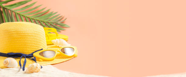 summer sand beach with hat,sandal and sunglasses on peach vintage color background.vacation banner mockup