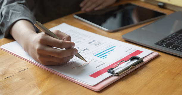 istock business woman analyse and discuss on business graph document 1256234505