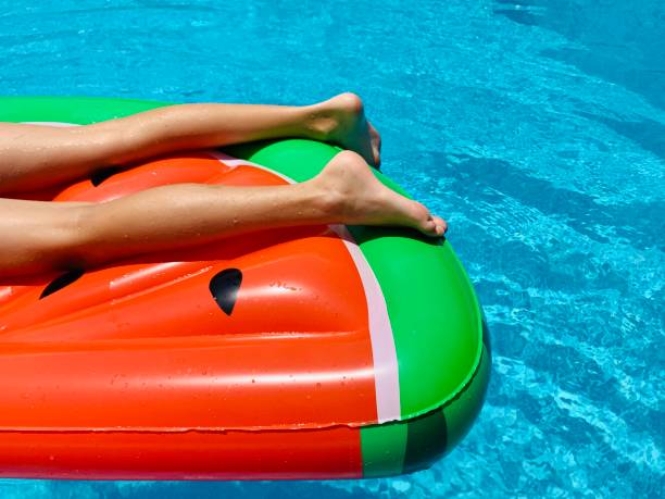istock Boy on inflatable watermelon in the swimming pool 1256235607