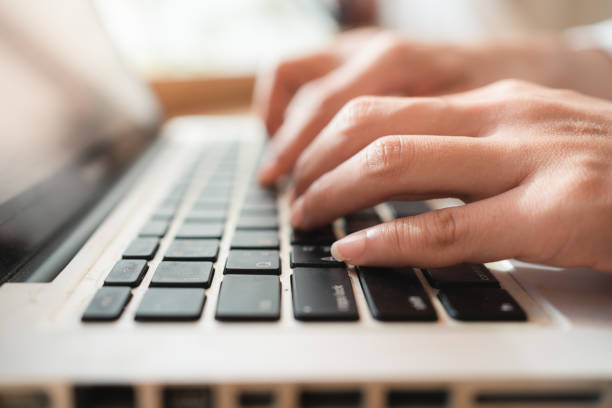 istock Close up hands of woman using laptop computer working and searching online information with blurry background. copy space of technology business and social distancing concept 1256236185