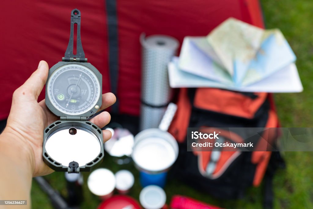 Camping tools on the grass Picture of camping tools on the grass - backpack, tent, gas tank, cans, compass, etc - ready to go in the woods Wilderness Stock Photo
