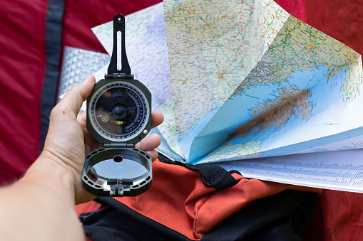 Close up picture of compass and map - preparing for camping trip in the woods