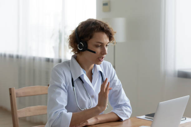 istock Woman doctor in headset have video call on computer 1256240235