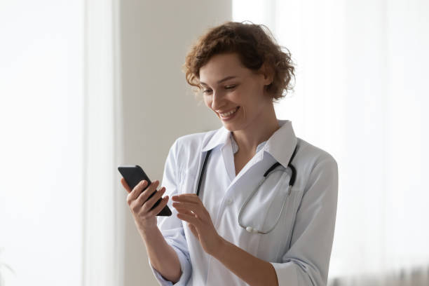 istock Smiling female doctor consult client on cellphone gadget 1256240260