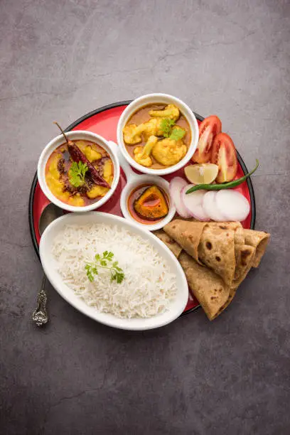 Indian Food Platter or Vegetarian Thali includes Dal Fry, Rice, Chapati and a type of vegetable with salad