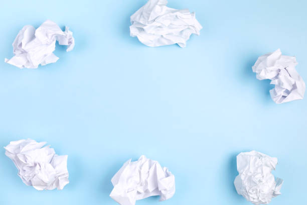 istock Crumpled white paper on blue background. Top view. Copy space 1256245654