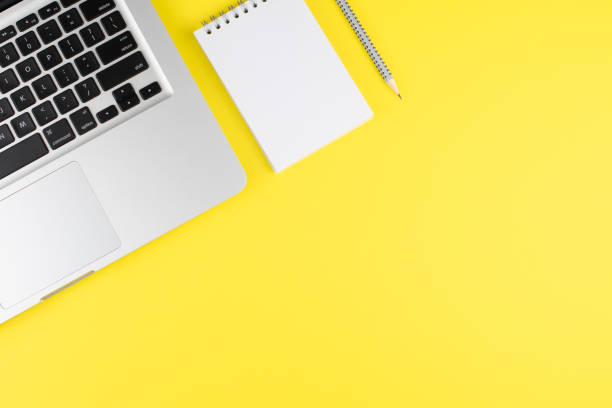 istock Notepad, pencil and laptop on yellow background. Top view with copy space. Workplace in the office. Office background. 1256245978