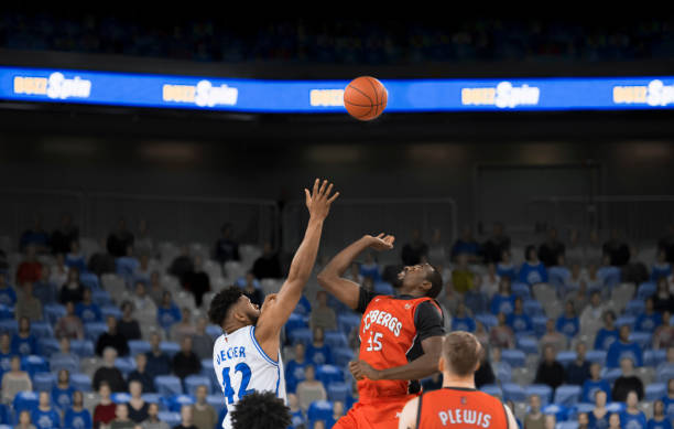 istock Basketball players reaching for ball 1256247138
