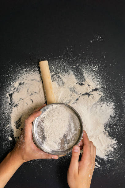 istock Males hands with flour for making dough, topview. on black background. vertical photo 1256249397