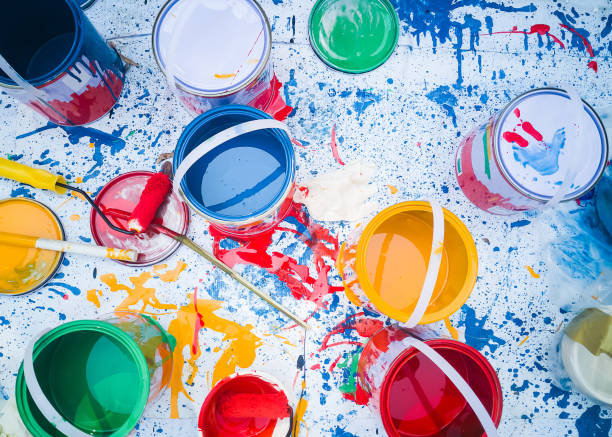 Abstract pattern with multicolored oil paintings with brushes Acrylic color top down, Can of paints with the motion of colored explosions Paints in tin buckets, and brushes on white canvas background.
