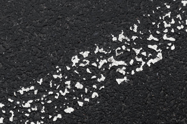 istock White grungy dividing line on dark tarmac 1256255047