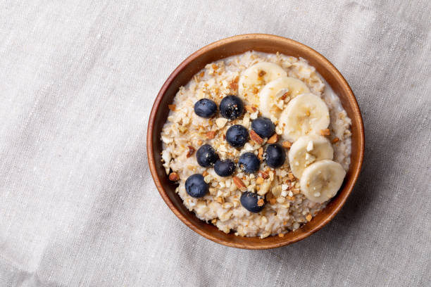 haferflocken mit bananen, heidelbeeren und mandeln. - oatmeal stock-fotos und bilder