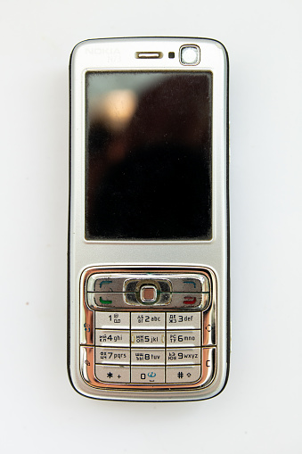 old push-button smartphone on white background