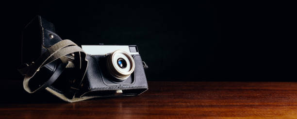 istock Vintage camera in a case on a wooden table on a dark background 1256259159