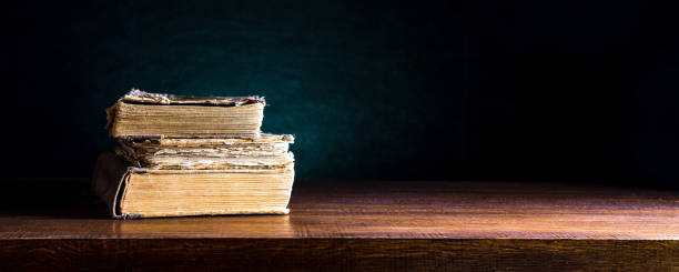 istock A stack of old books on a wooden background. Space for text or design 1256259169
