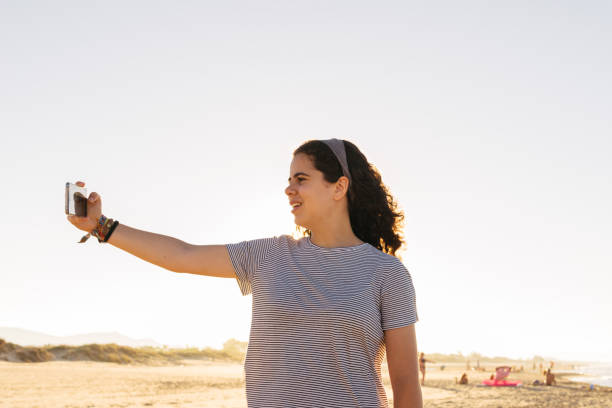 istock Man Photographing On Beach Against Clear Sky 1256260757